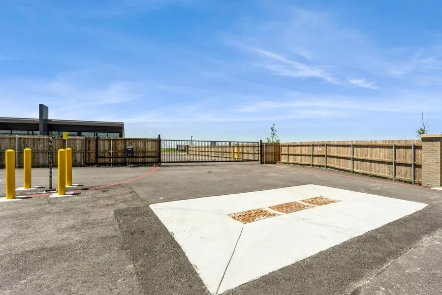Parking spaces in front of the security office and entry gate for a RV parking lot. A RV can be just beyond the fence.