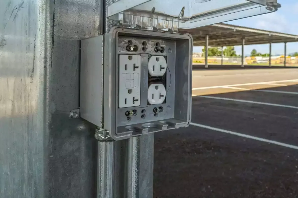 Power outlet with cover at parking space.