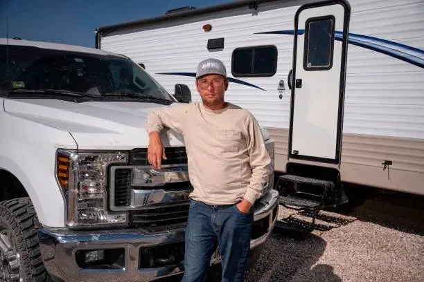 Man standing in front of his truck and RV