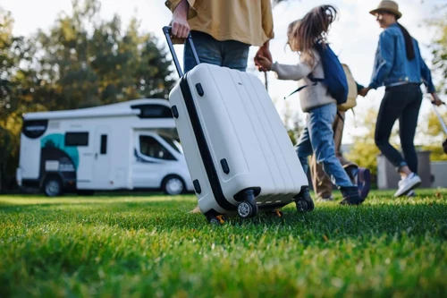 A young family with luggage preparing for an RV road trip.